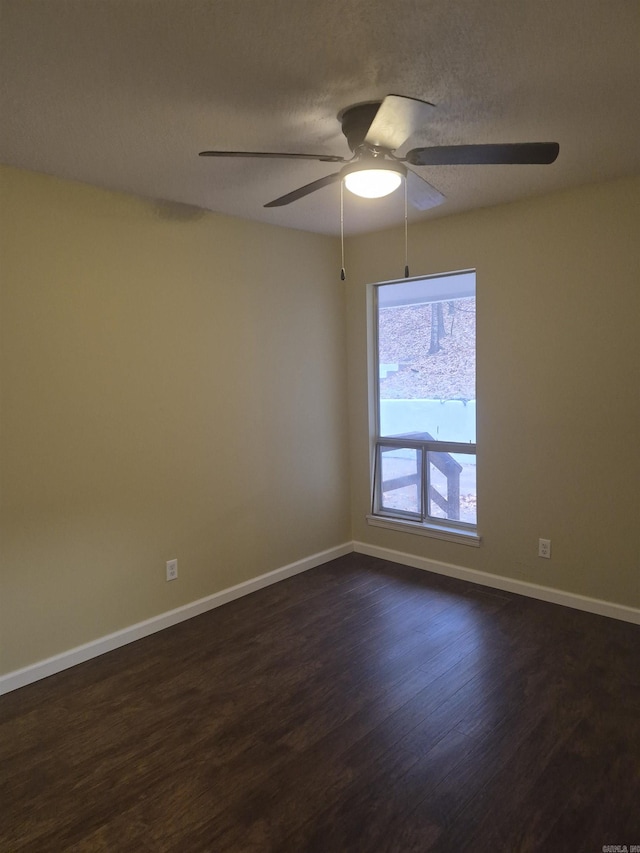 empty room with ceiling fan, dark hardwood / wood-style flooring, and a textured ceiling