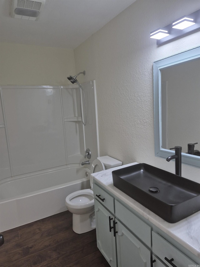 full bathroom featuring washtub / shower combination, wood-type flooring, vanity, and toilet