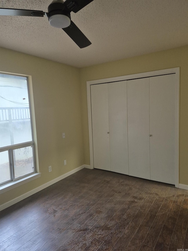 unfurnished bedroom featuring dark hardwood / wood-style flooring, a textured ceiling, a closet, and ceiling fan