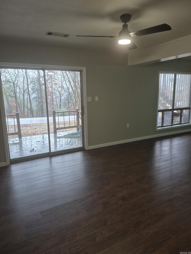 unfurnished room featuring ceiling fan, dark hardwood / wood-style flooring, and plenty of natural light