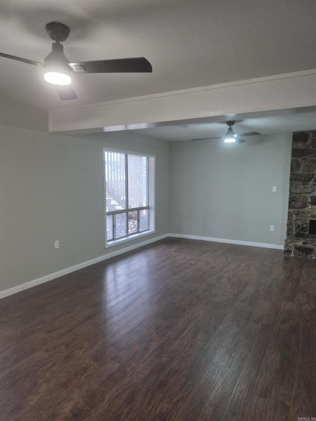 unfurnished room with dark hardwood / wood-style floors and a stone fireplace