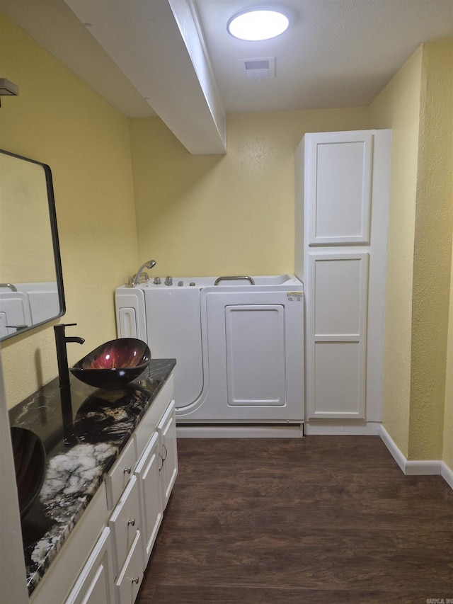 laundry area with cabinets, sink, and dark wood-type flooring