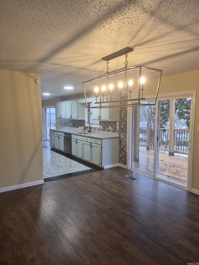 kitchen with sink, stainless steel dishwasher, decorative light fixtures, decorative backsplash, and white cabinets