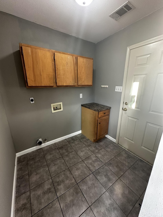 laundry room featuring washer hookup, hookup for an electric dryer, cabinets, and dark tile patterned flooring