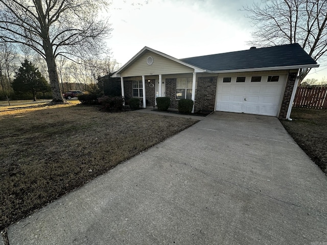 ranch-style home with a garage, covered porch, and a front lawn