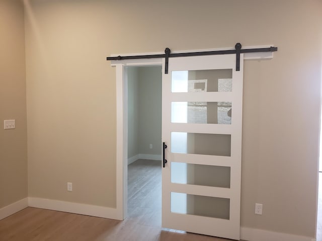 interior space with a barn door and light wood-type flooring