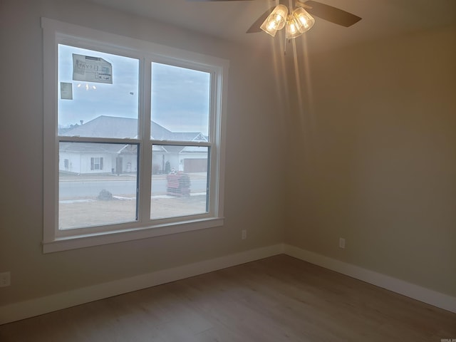 unfurnished room featuring wood-type flooring, a wealth of natural light, and ceiling fan