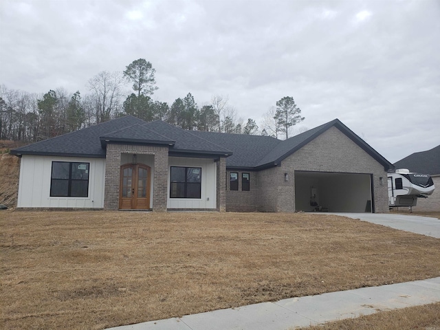 view of front of home with french doors, a garage, and a front yard