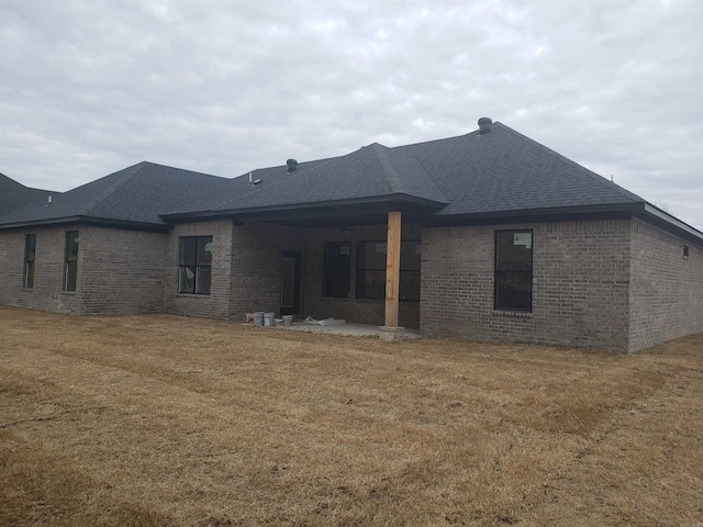 rear view of property featuring a lawn