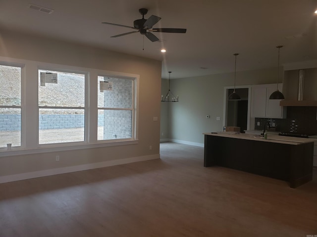 kitchen with backsplash, a wealth of natural light, ceiling fan, and decorative light fixtures