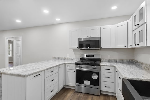 kitchen with white cabinets, kitchen peninsula, and stainless steel appliances