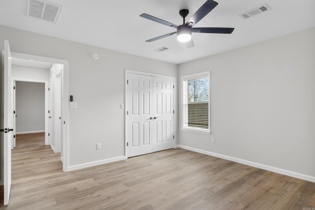 unfurnished bedroom featuring a closet, light hardwood / wood-style floors, and ceiling fan