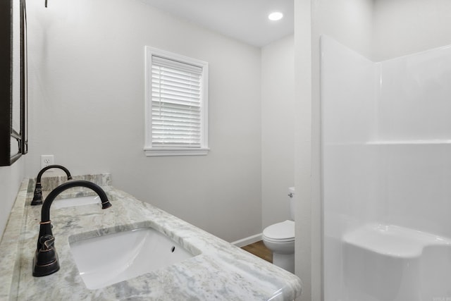 bathroom featuring wood-type flooring, vanity, and toilet