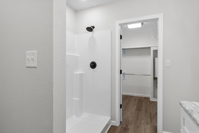 bathroom with a shower and wood-type flooring