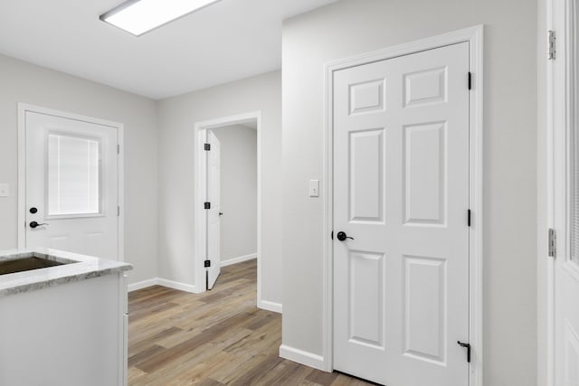 corridor featuring sink and light hardwood / wood-style flooring