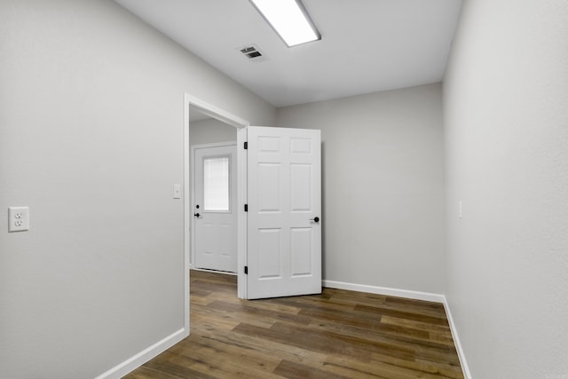 unfurnished room with dark wood-type flooring