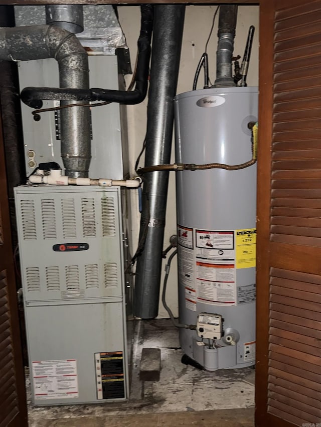 utility room featuring heating unit and water heater