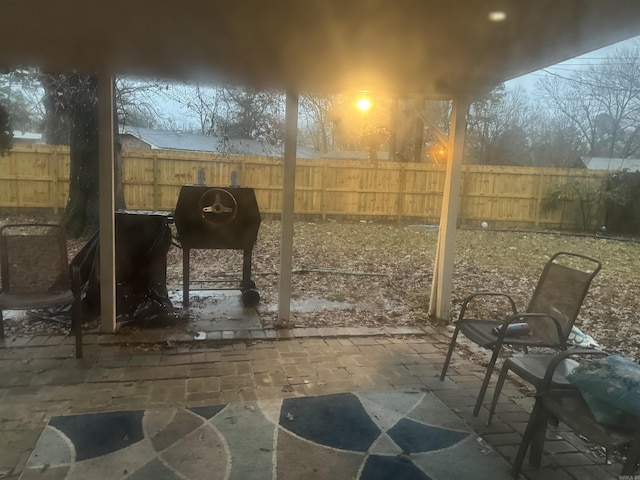 patio terrace at dusk featuring area for grilling