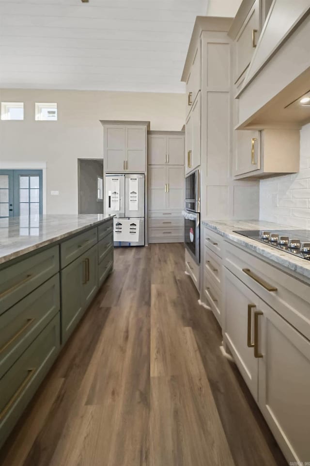 kitchen featuring light stone countertops, dark hardwood / wood-style flooring, black cooktop, backsplash, and double wall oven