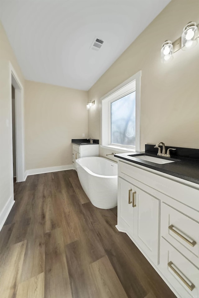 bathroom with a tub, vanity, and hardwood / wood-style flooring