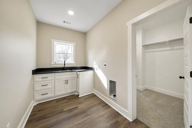 laundry area with hookup for an electric dryer, dark hardwood / wood-style flooring, and sink