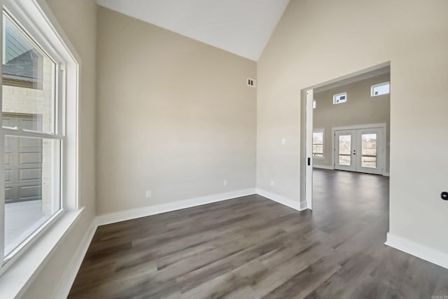 spare room featuring french doors, high vaulted ceiling, and dark wood-type flooring