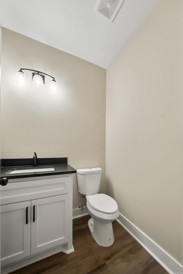 bathroom with vanity, toilet, and wood-type flooring