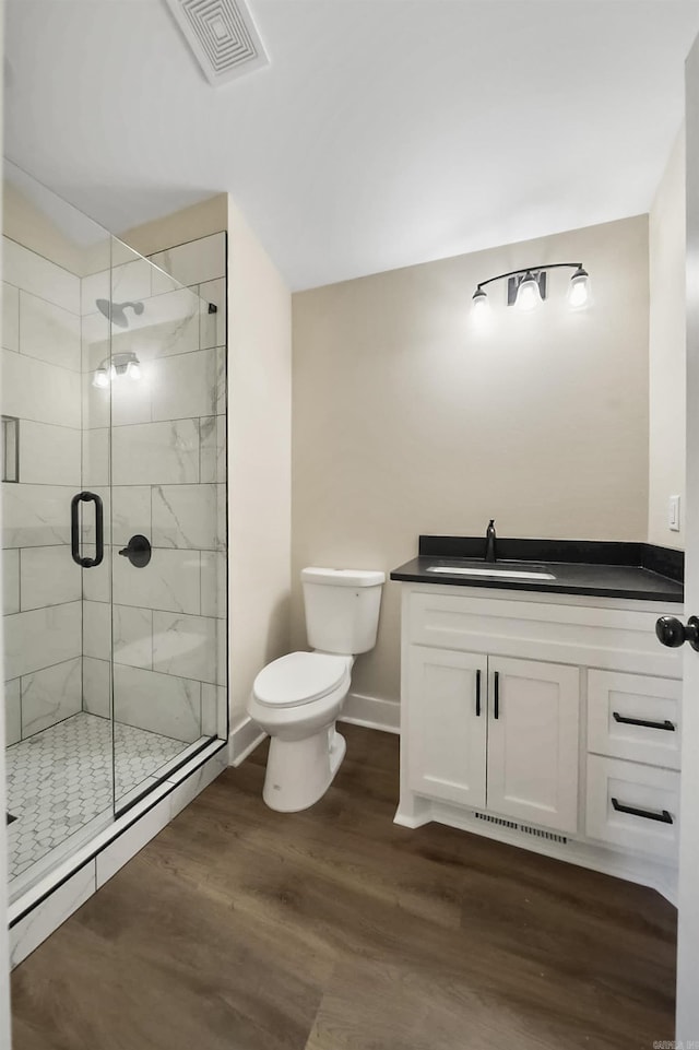 bathroom featuring an enclosed shower, vanity, toilet, and wood-type flooring