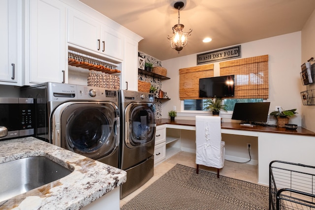 laundry area with cabinets, a notable chandelier, washing machine and dryer, and light tile patterned floors