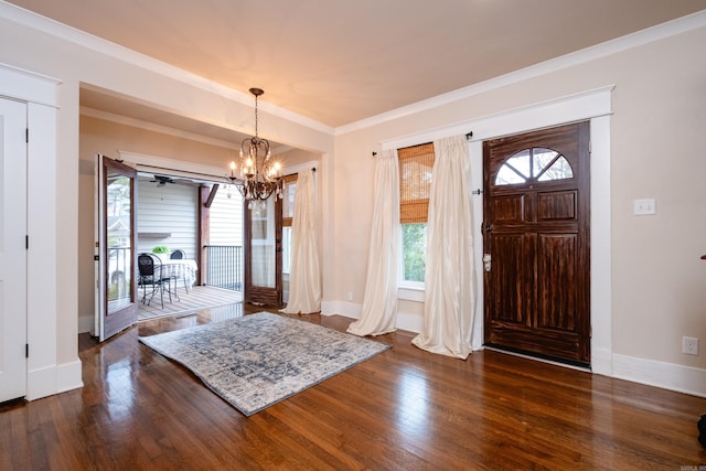 entryway with dark hardwood / wood-style flooring, crown molding, and a notable chandelier