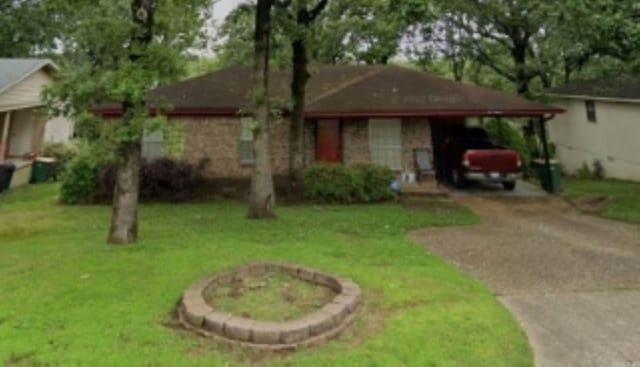 ranch-style home featuring a carport and a front yard