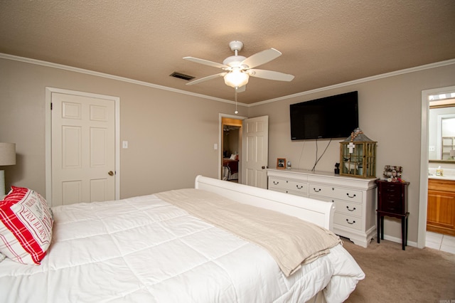 bedroom featuring ensuite bath, ceiling fan, a textured ceiling, light carpet, and ornamental molding