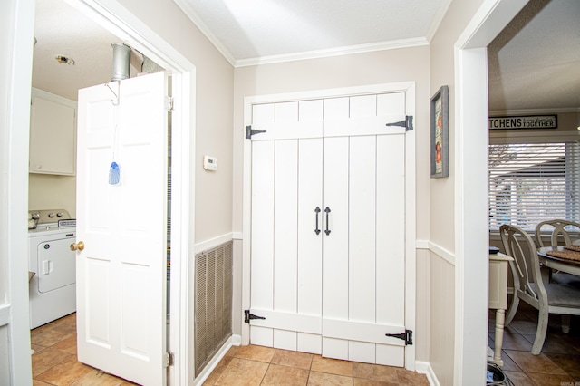 corridor with washer / clothes dryer, crown molding, and light tile patterned flooring