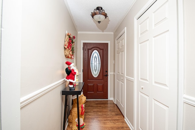 doorway with dark hardwood / wood-style flooring, a textured ceiling, and crown molding