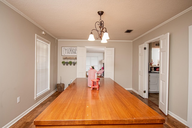 dining room featuring a textured ceiling, an inviting chandelier, and crown molding