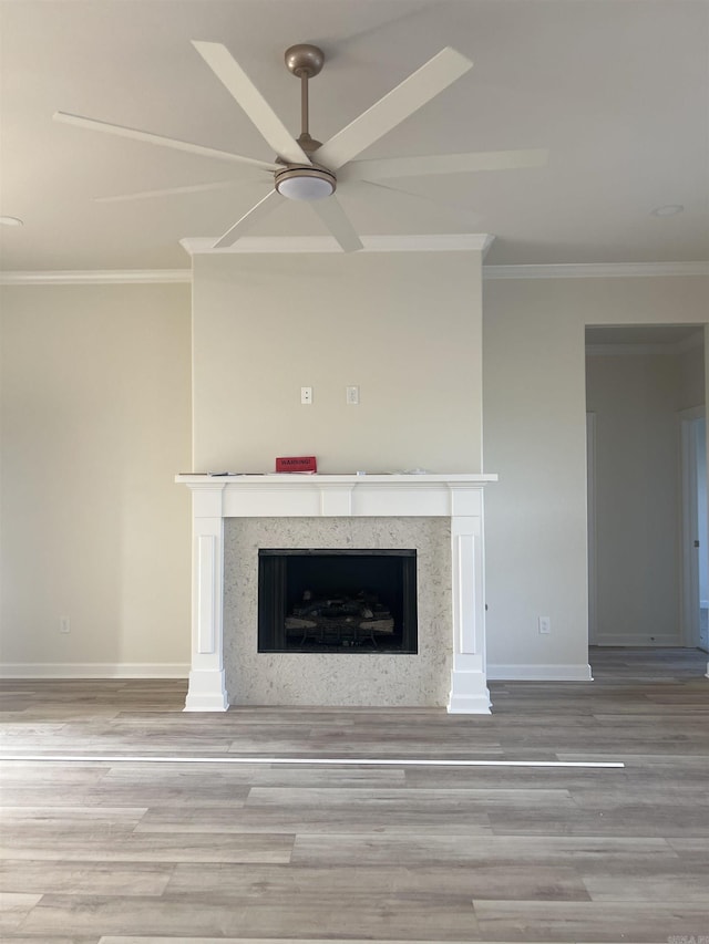 details with wood finished floors, ornamental molding, a fireplace, baseboards, and a ceiling fan