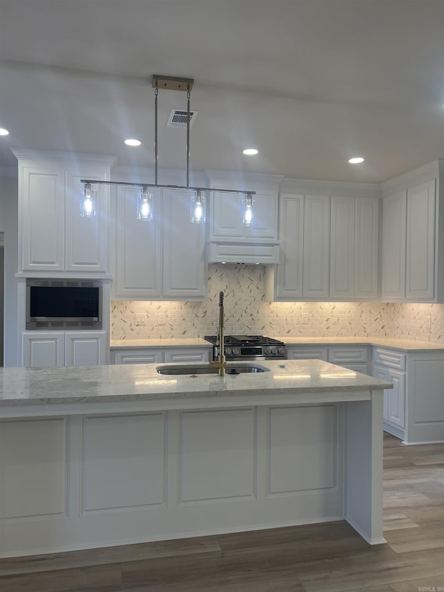 kitchen with visible vents, white cabinetry, and tasteful backsplash