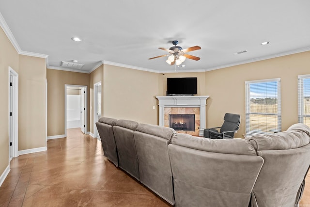 living room featuring a tiled fireplace, crown molding, and ceiling fan