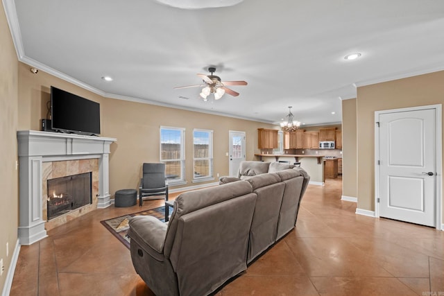 tiled living room with a fireplace, ceiling fan with notable chandelier, and ornamental molding