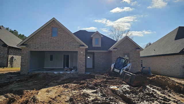 view of front of home featuring a garage, a patio, and brick siding