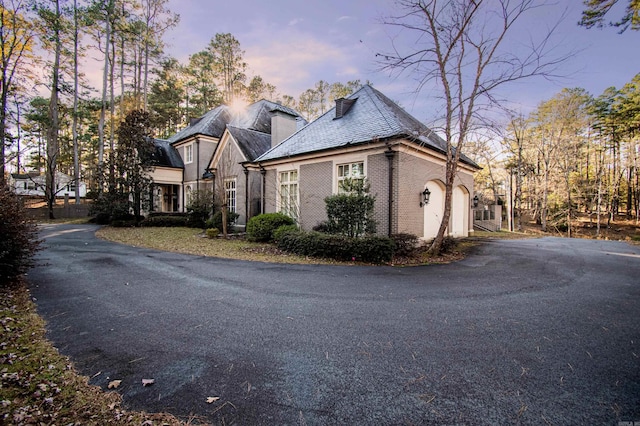 property exterior at dusk featuring a garage