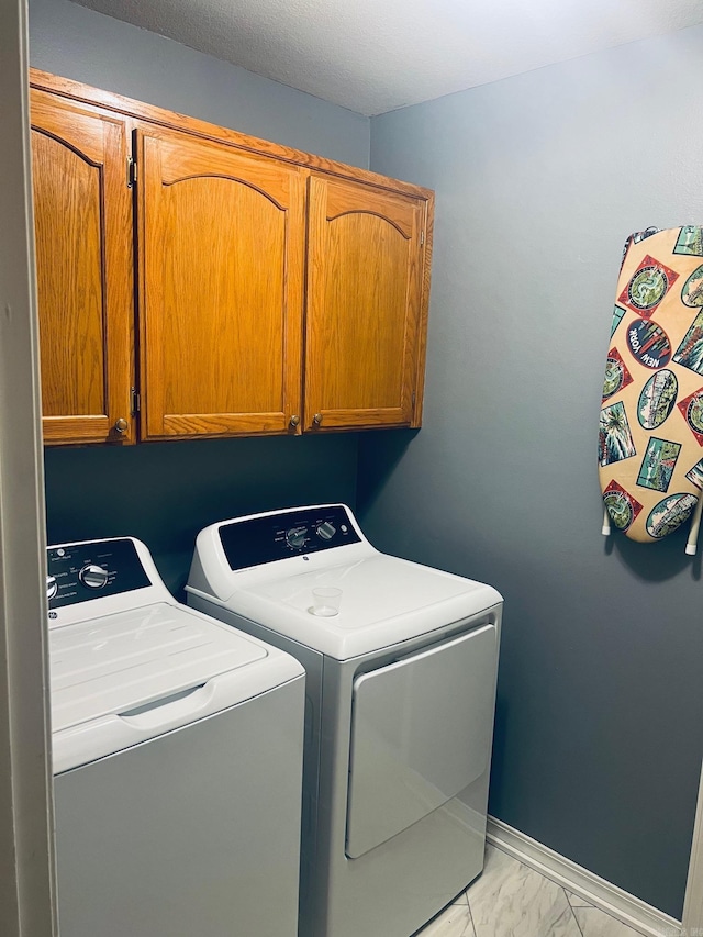 washroom featuring cabinets and independent washer and dryer