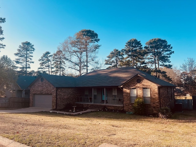 single story home featuring a front yard, a porch, and a garage