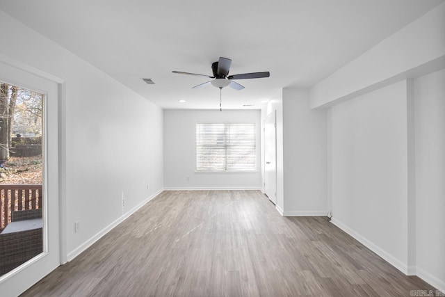 unfurnished room with hardwood / wood-style floors, ceiling fan, and a wealth of natural light