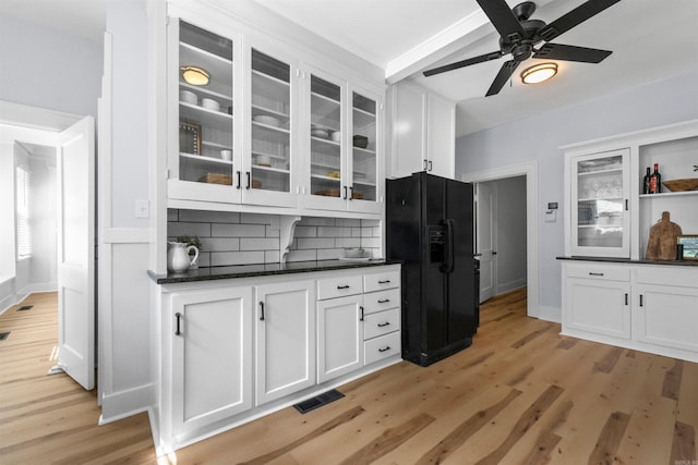 kitchen featuring light wood-type flooring, backsplash, white cabinetry, and black refrigerator with ice dispenser