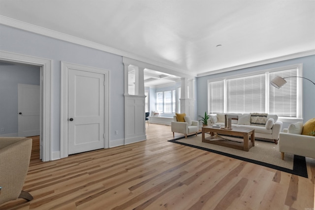 living room featuring light hardwood / wood-style flooring, ornamental molding, and ornate columns