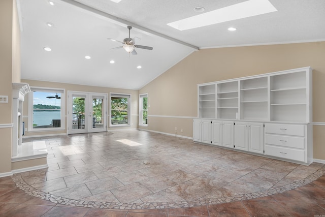 unfurnished living room with ceiling fan, lofted ceiling with skylight, and french doors