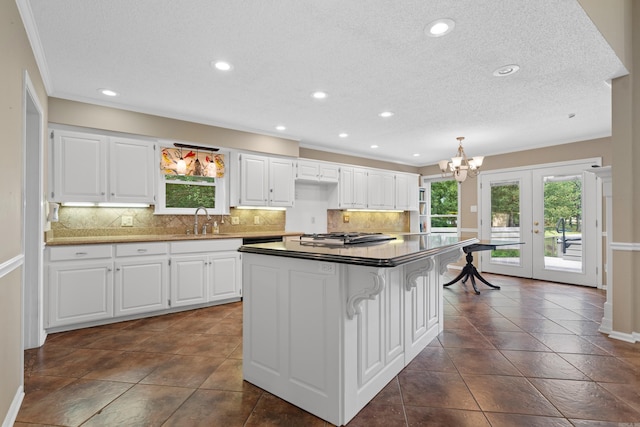 kitchen with a center island, french doors, white cabinets, and a kitchen breakfast bar