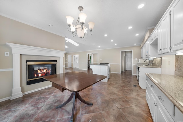 unfurnished dining area featuring an inviting chandelier, ornamental molding, and sink