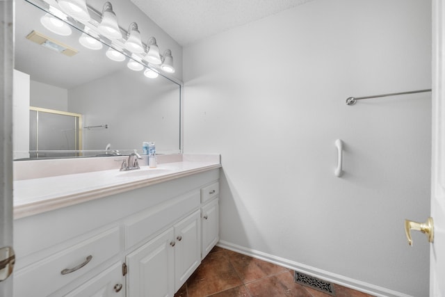 bathroom featuring vanity, an enclosed shower, and a textured ceiling